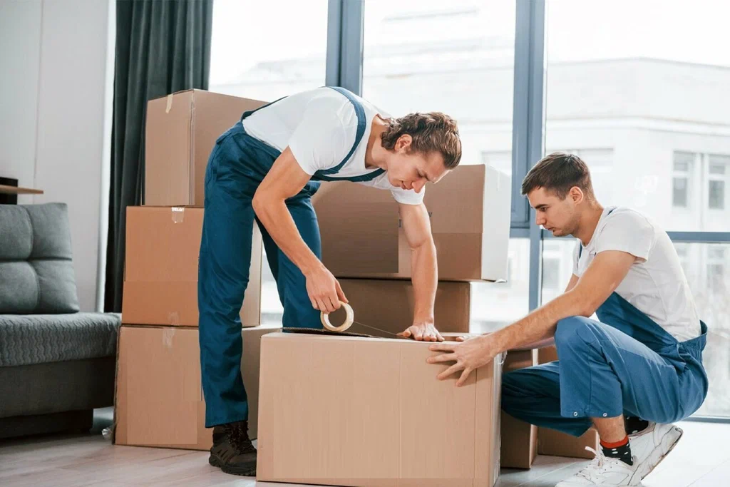 Best house moving company in Dubai providing professional home relocation with movers loading furniture, boxes, and household items into a truck outside a modern Dubai villa.