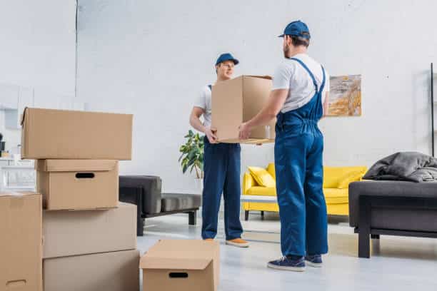 House movers in Karama Dubai providing professional home relocation service with team carefully packing and loading furniture, boxes, and household items into a moving truck outside a residential building.