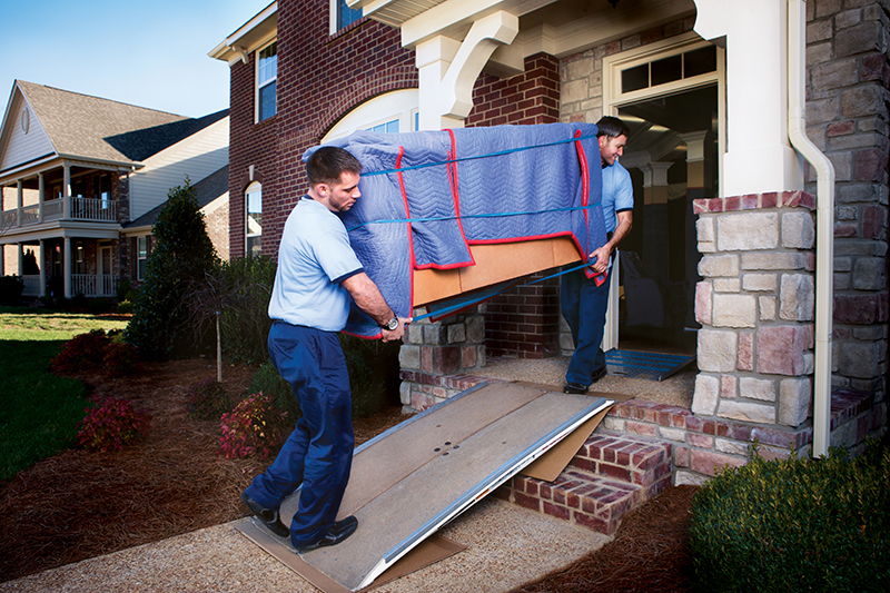 Movers in Al Barsha Dubai providing professional relocation service with team carefully packing, loading, and transporting household furniture, boxes, and items into a moving truck outside a residential building.