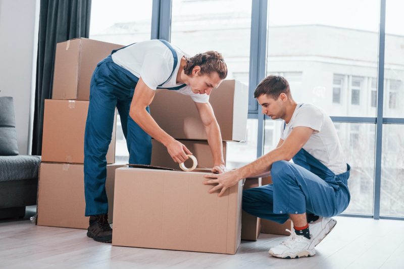 Villa movers in Dubai handling luxury home relocation with professional team loading furniture, boxes, and household items into a moving truck outside a modern villa.