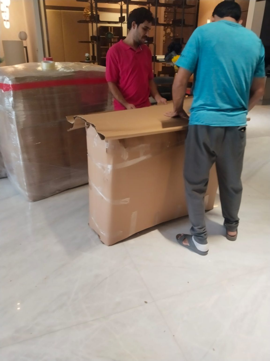 Trusted movers and packers in Dubai with boxes and furniture wrapped in stretch film and tied with straps